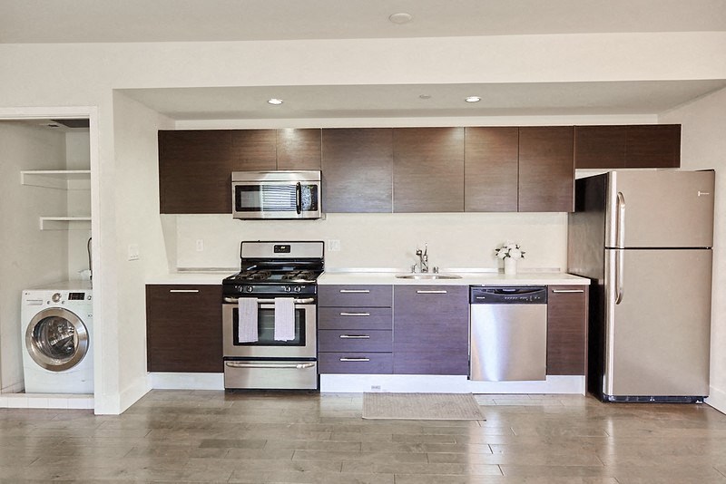 a kitchen with stainless steel appliances and a washing machine