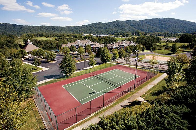 an aerial view of a tennis court with trees and buildings