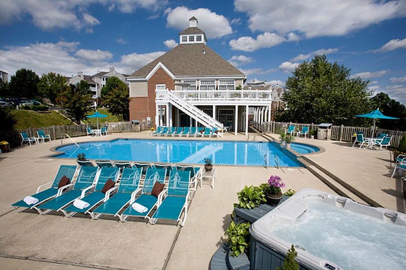 a large swimming pool with chairs and a building