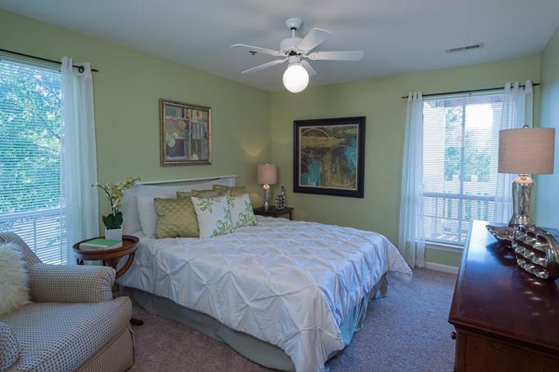 a bedroom with a bed and a ceiling fan