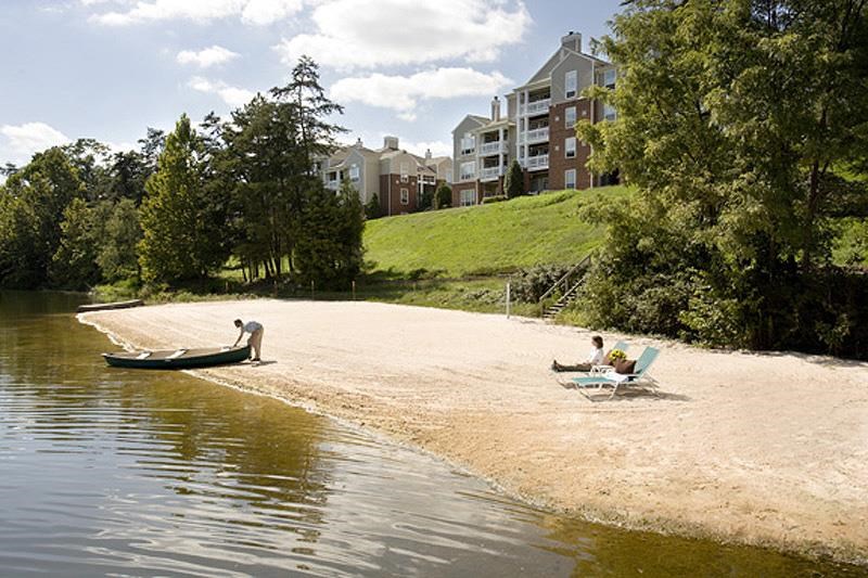 a couple of people sitting on a beach with a boat