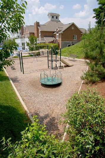 a playground in a park with a house in the background
