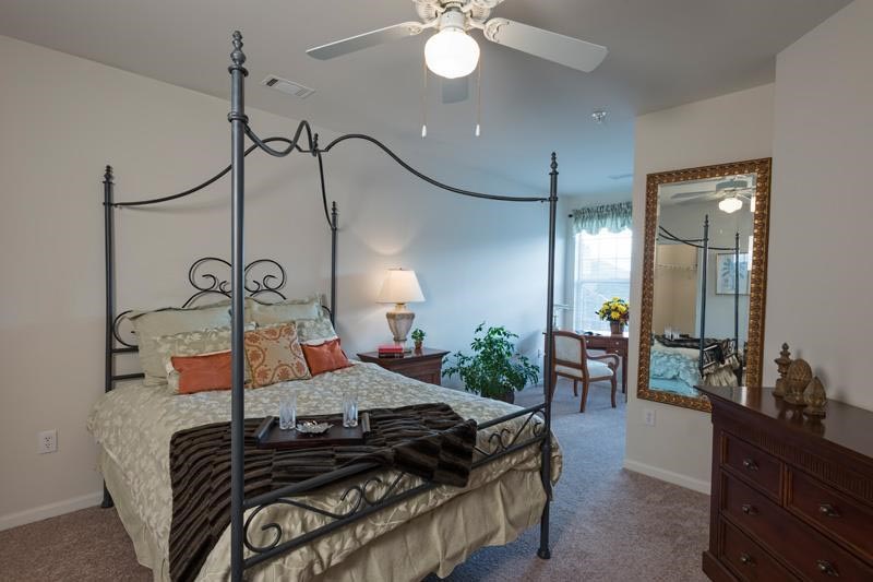 a bedroom with a bed and a ceiling fan