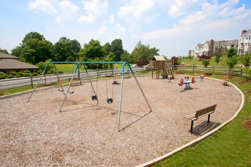 children playing on a swing set at a park