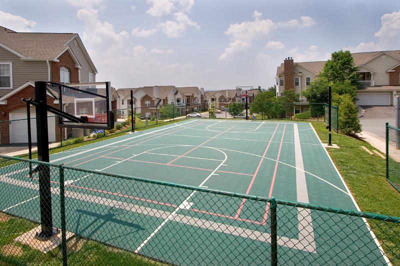 a tennis court with apartments in the background