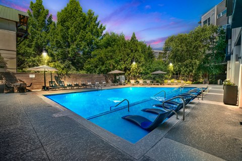 a swimming pool at a hotel with chairs around it