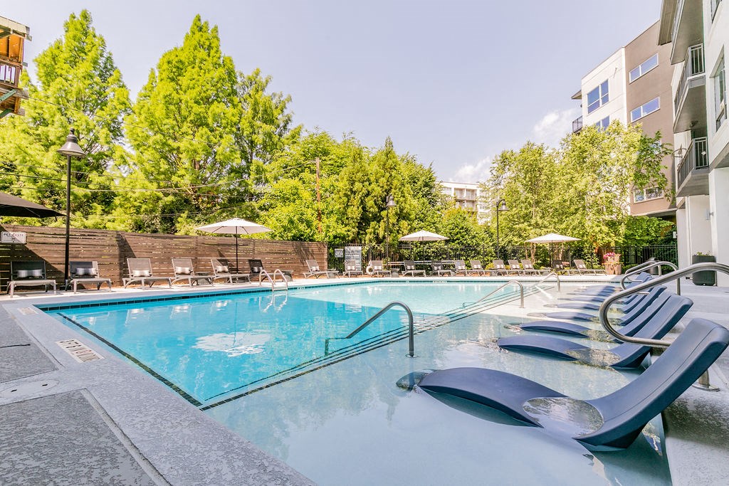 a swimming pool at a hotel with chairs around it