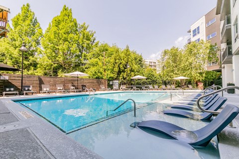 a swimming pool at a hotel with chairs around it