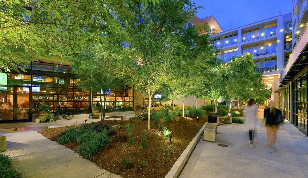 people walking down a sidewalk in a city at night