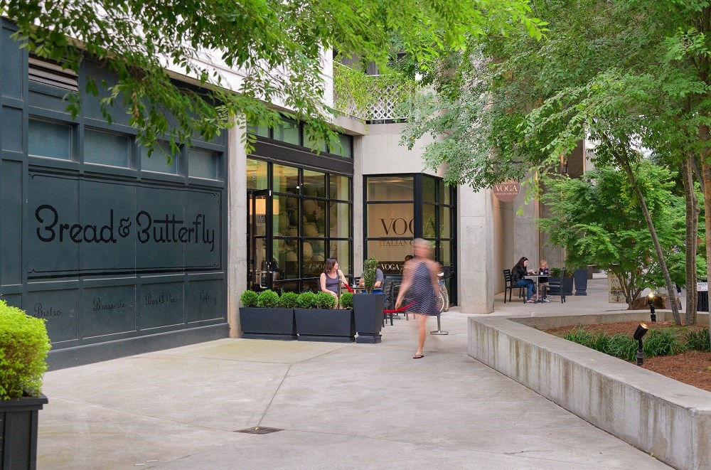 a woman walking down a sidewalk in front of a building