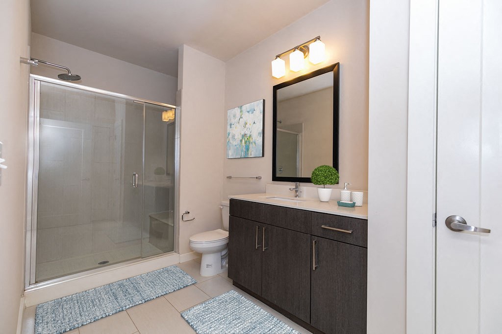 a bathroom with a shower and a sink and a mirror