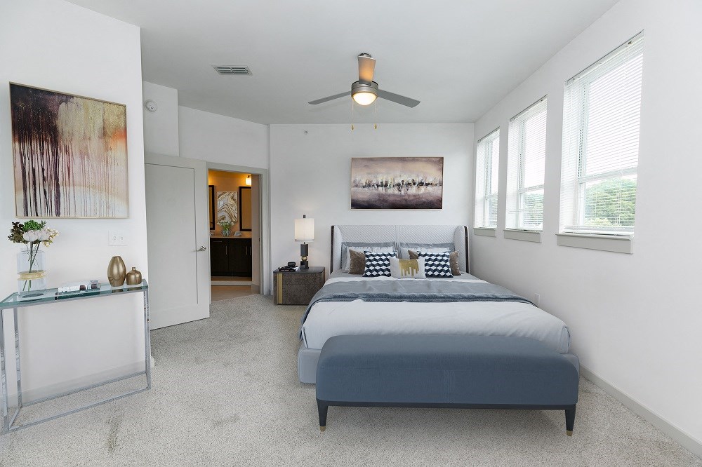a bedroom with a bed and a ceiling fan