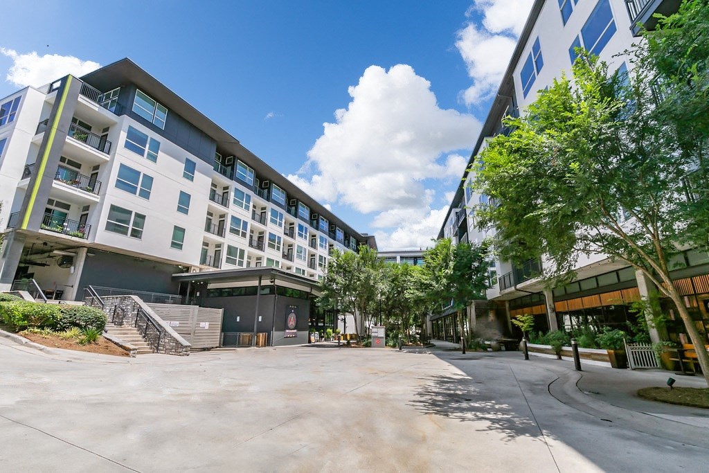 a city street with buildings and trees and a blue sky