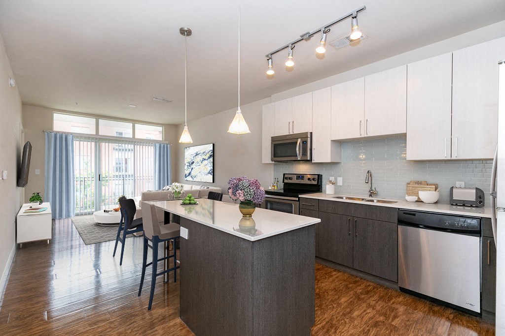 a kitchen with an island and a living room