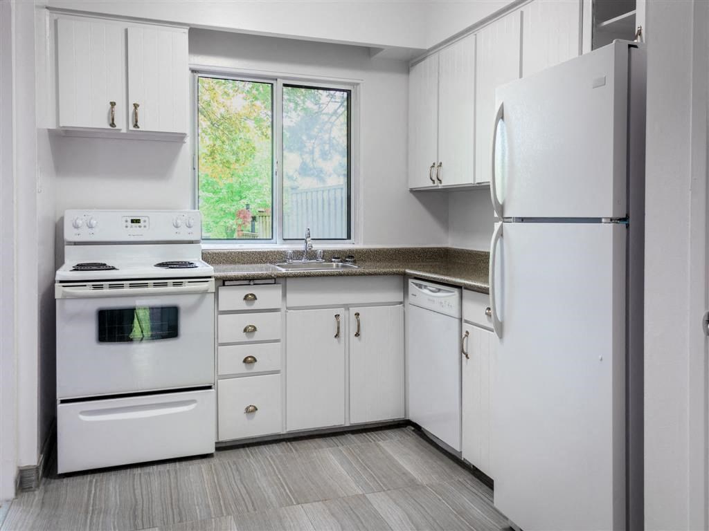 a white kitchen with white appliances and white cabinets