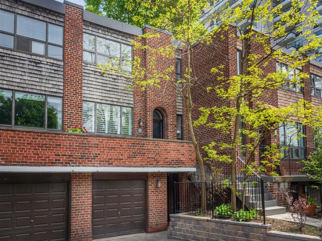 a building with two garage doors and a tree in front of it