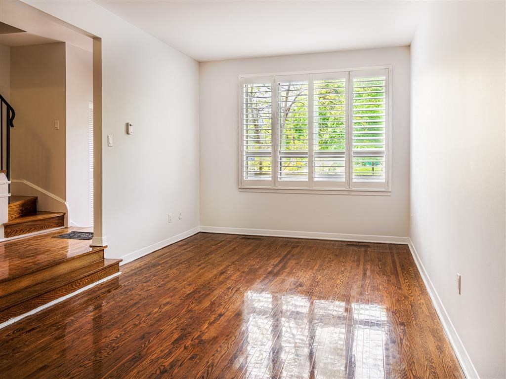 a empty room with a window and wooden floors