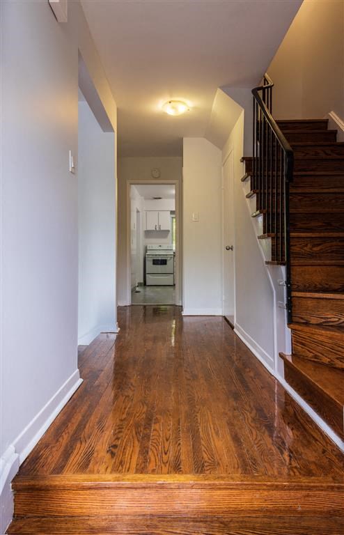 a hallway with a wooden floor and a staircase