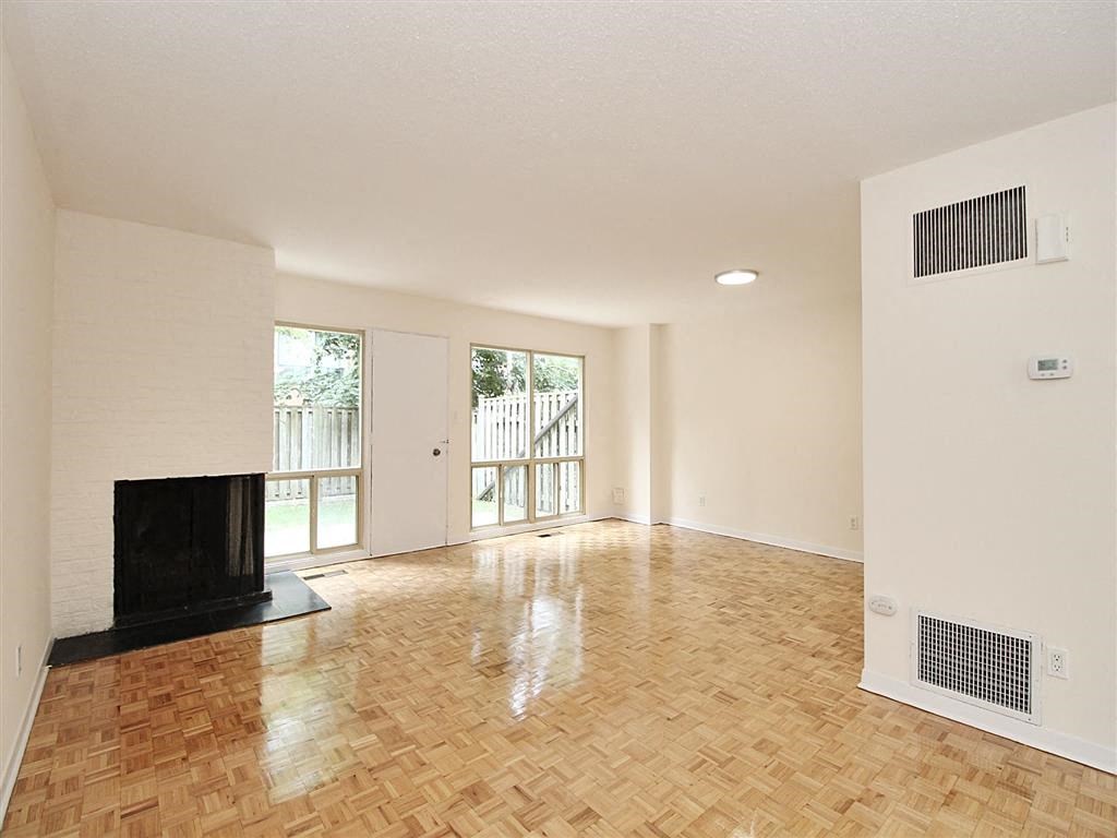 an empty living room with a fireplace and a sliding glass door