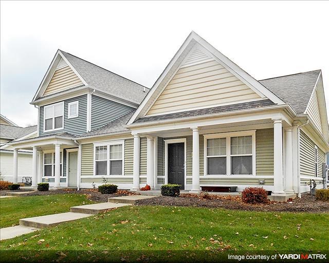 a white house with a porch and a yard