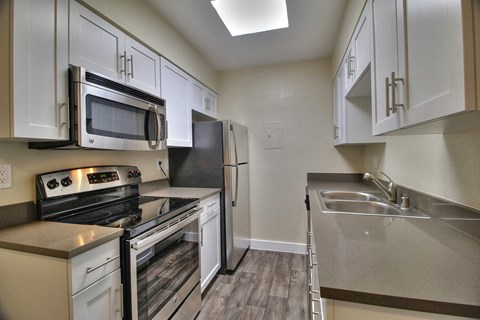 a kitchen with stainless steel appliances and white cabinets