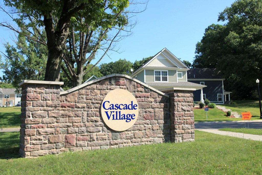 a stone wall with a sign on it in front of a house
