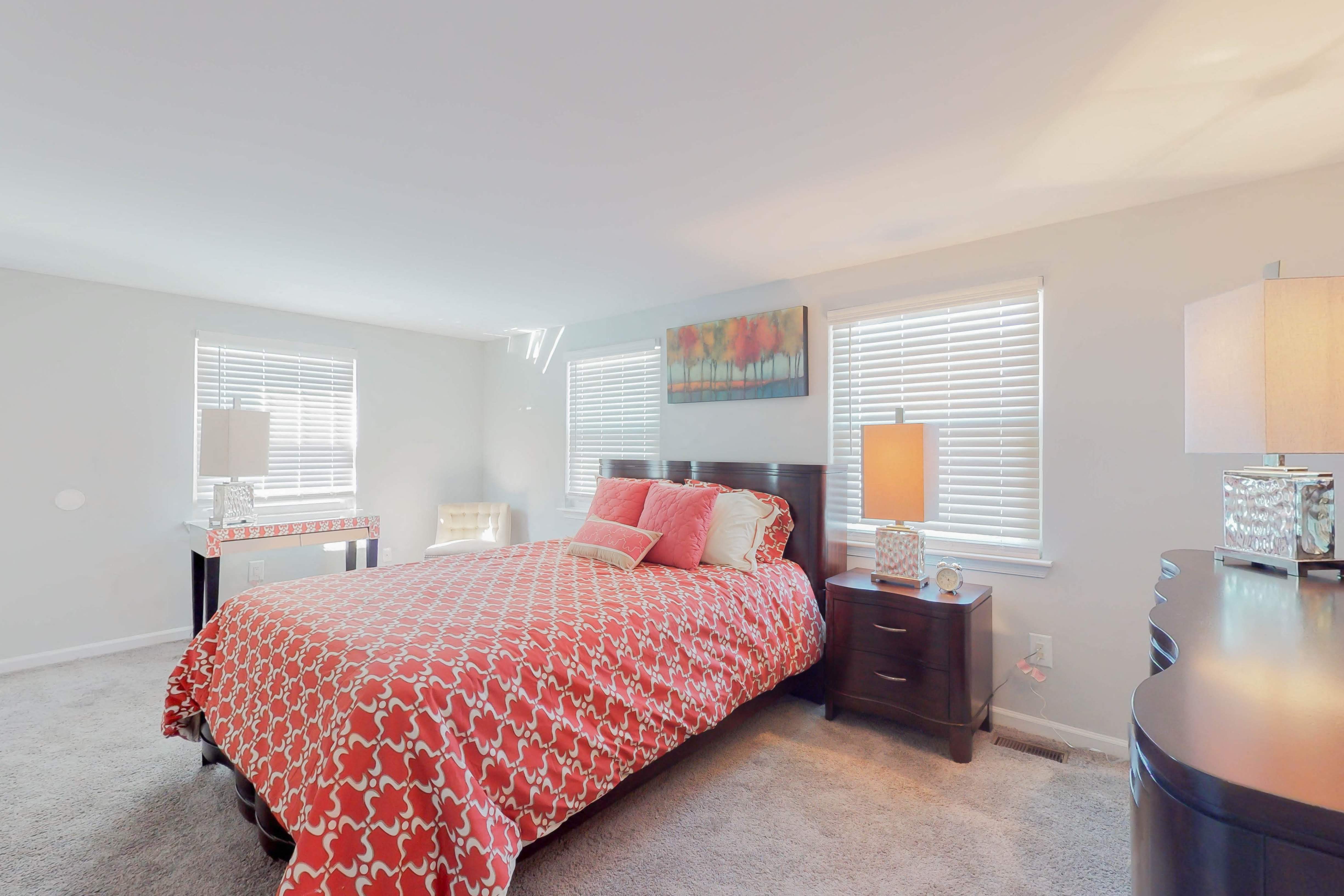 a bedroom with a bed and two windows