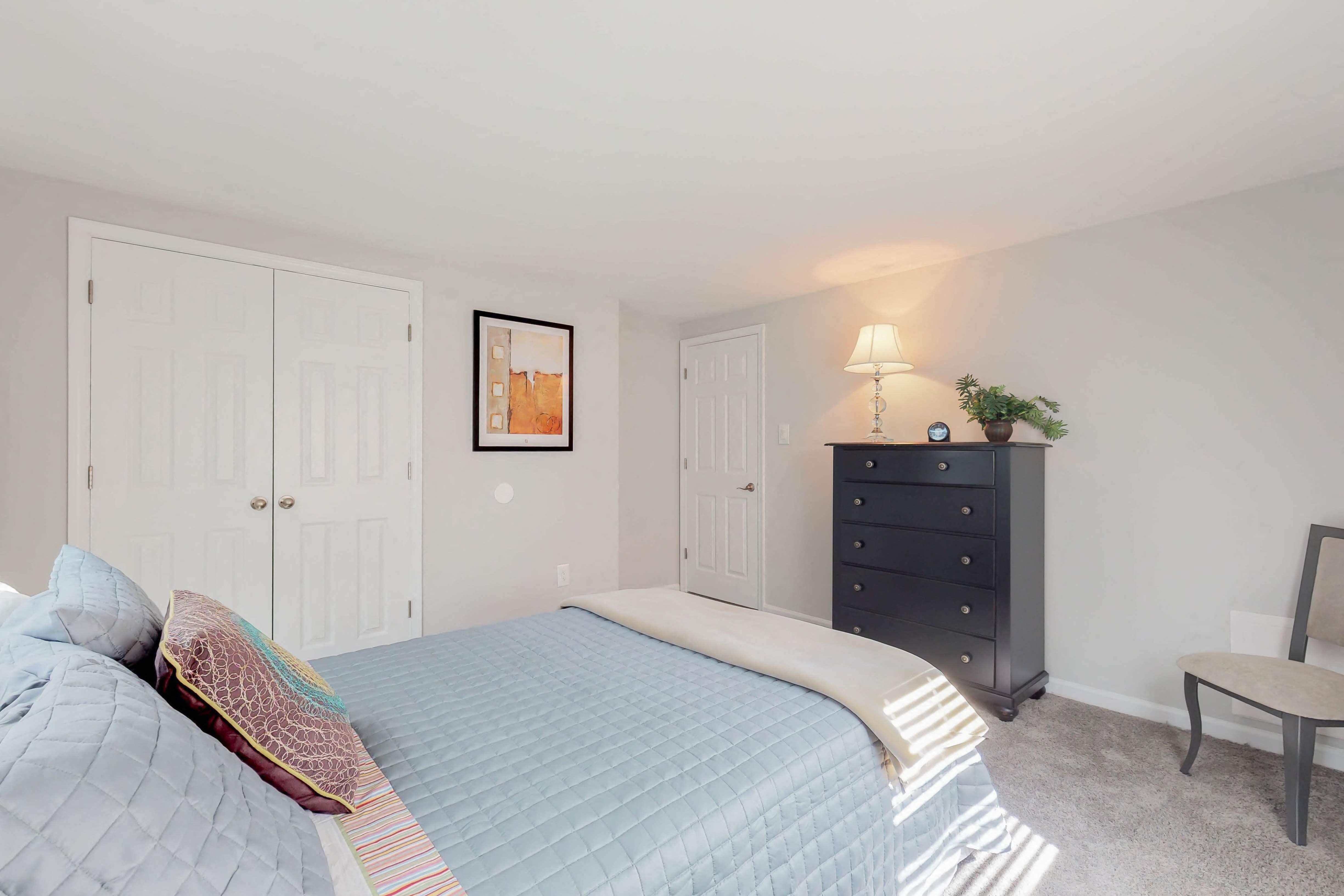 a bedroom with a large bed and a dresser