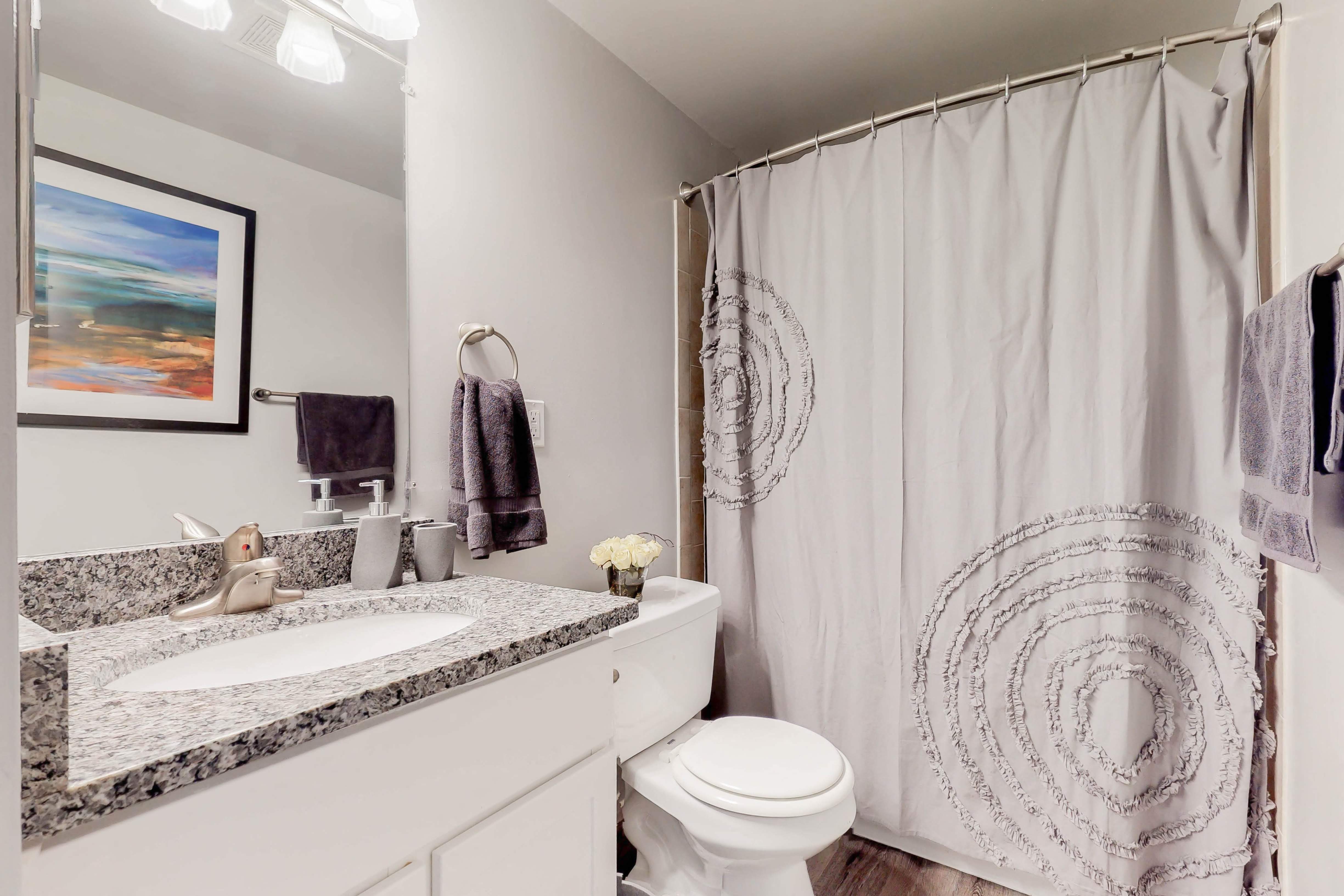 a bathroom with a shower and a sink and a toilet