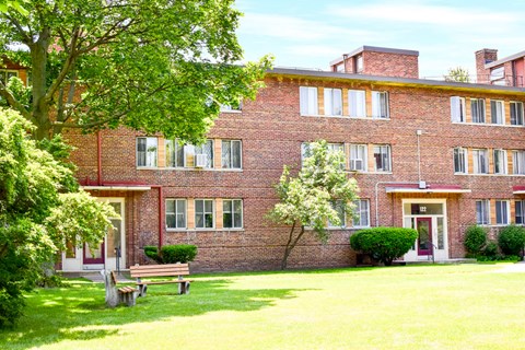 a large brick building with a bench in front of it