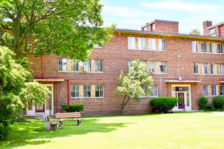 a large brick building with a bench in front of it