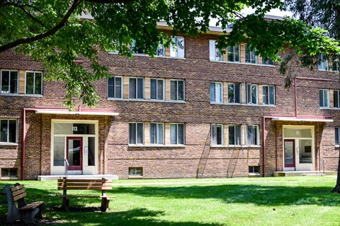 a bench sitting in front of a brick building