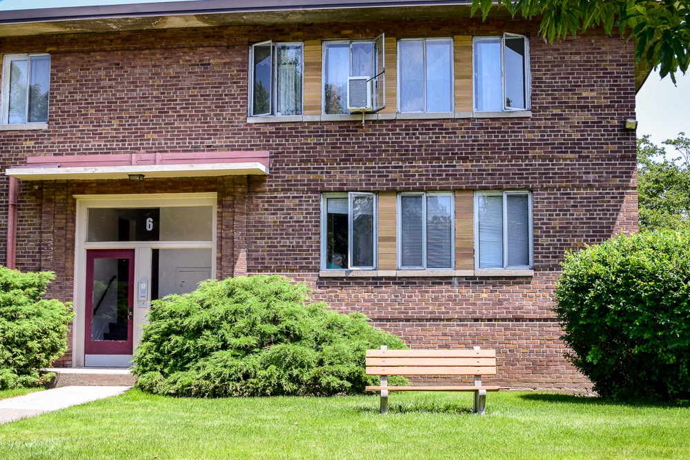 a wooden bench in front of a brick building