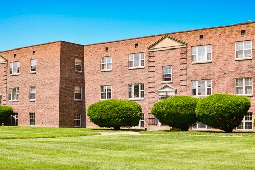 a brick building with green grass in front of it