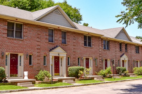 a red brick church with red doors and a street