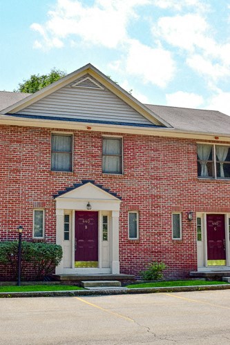 the front of a red brick church with two red doors