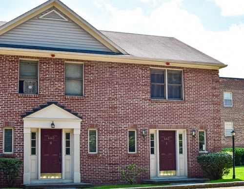 the front of a brick house with two doors
