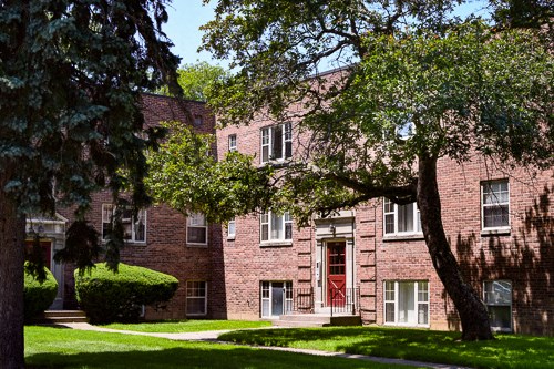 a red brick building with a tree in front of it