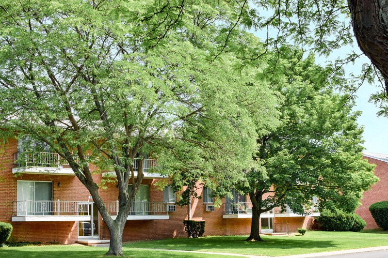 an apartment building with trees in front of it