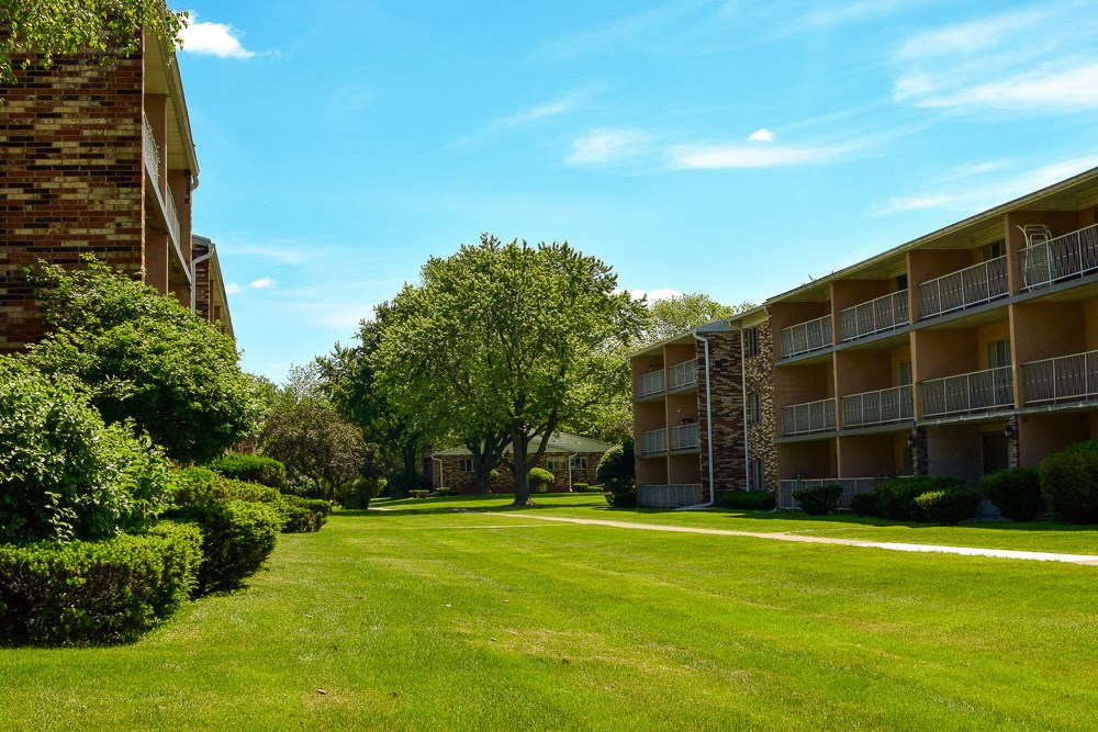 a green lawn in front of an apartment building