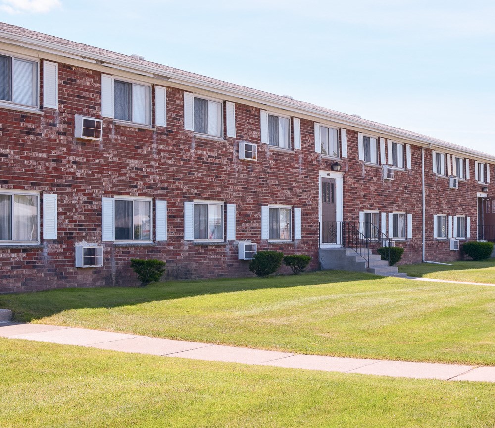 a brick building with windows and a lawn