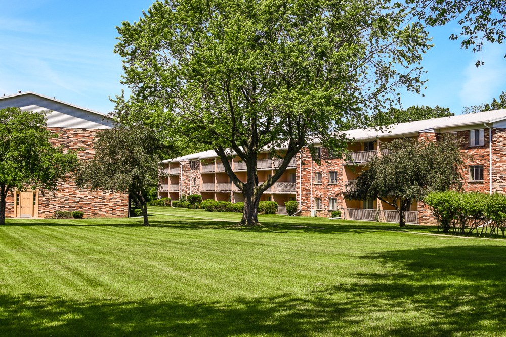 a large green lawn in front of an apartment building