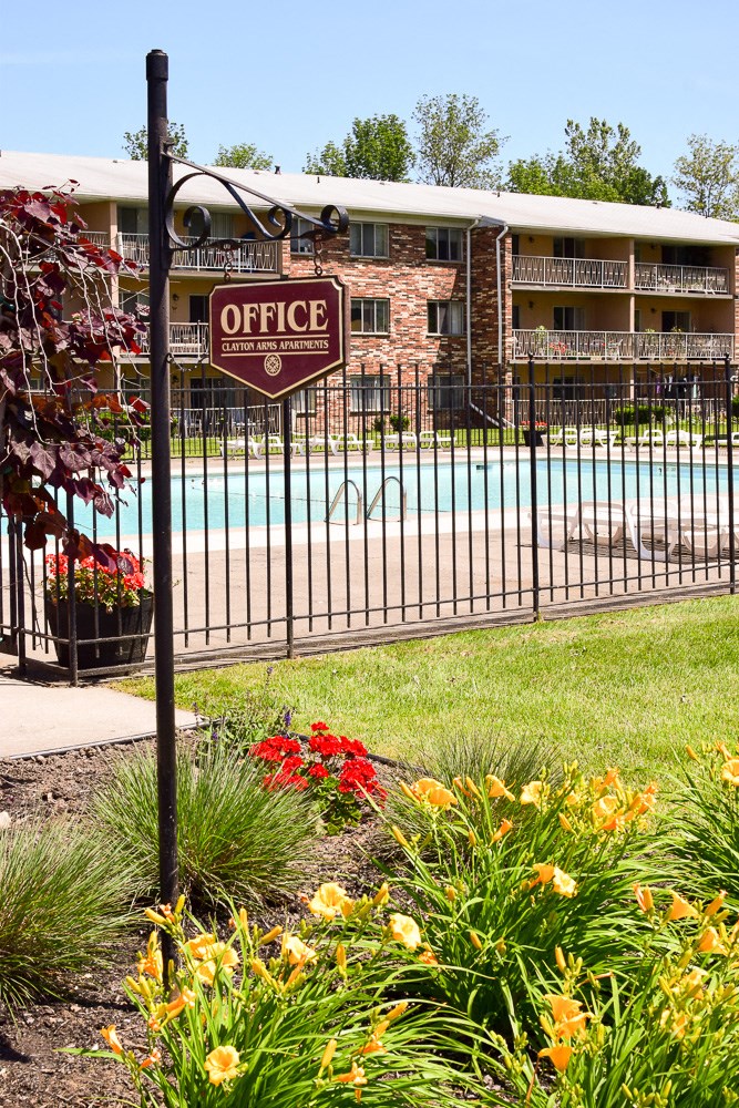 a pool with a sign on a fence in front of a building
