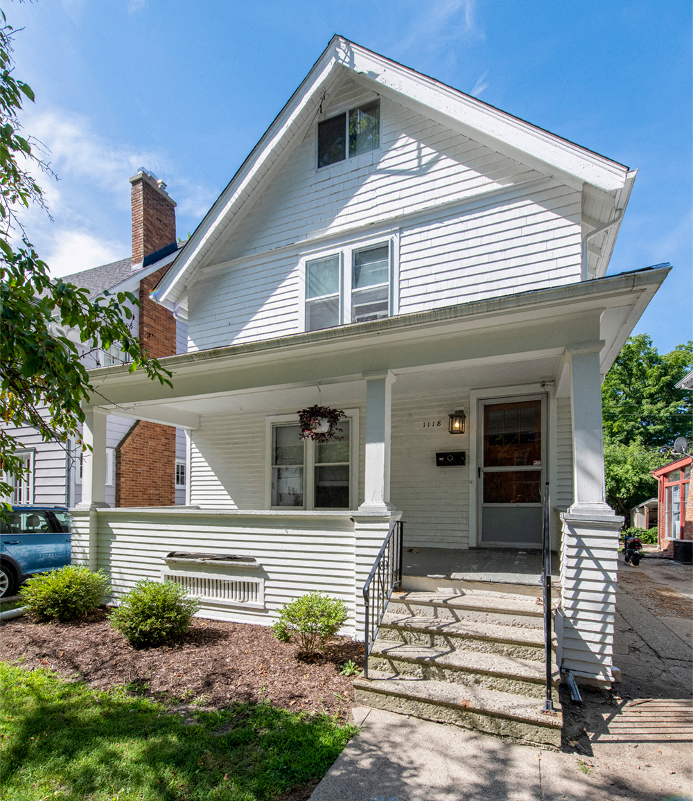 a white house with a front porch and steps