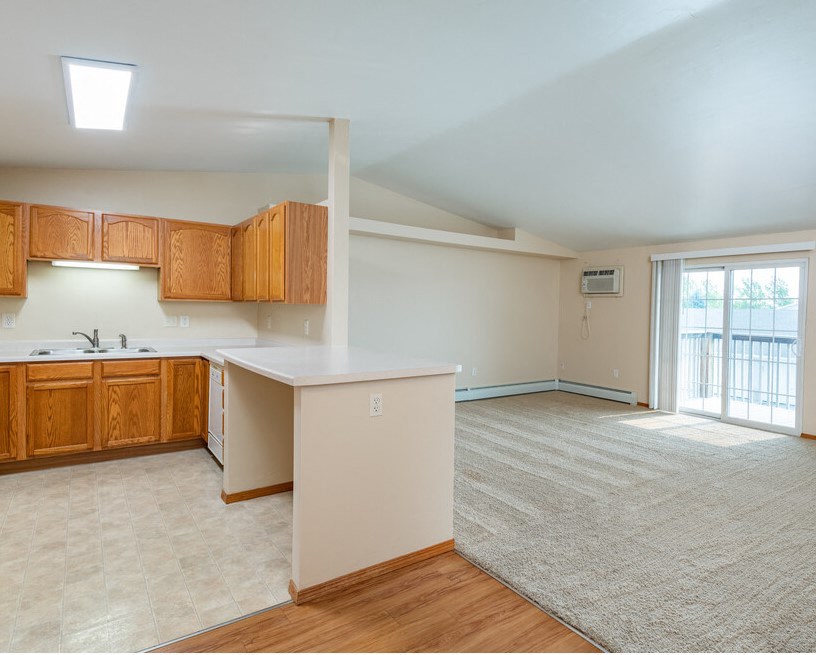 Kitchen with Open Concept Living Area with A/C Unit and Balcony