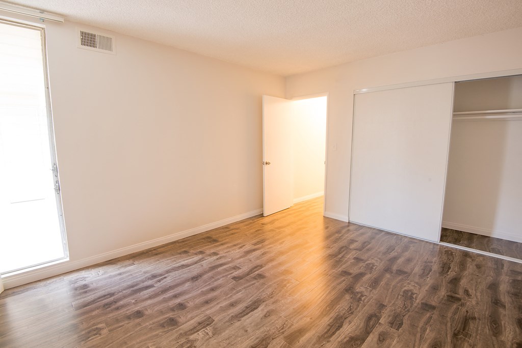 an empty living room with wood flooring and white walls