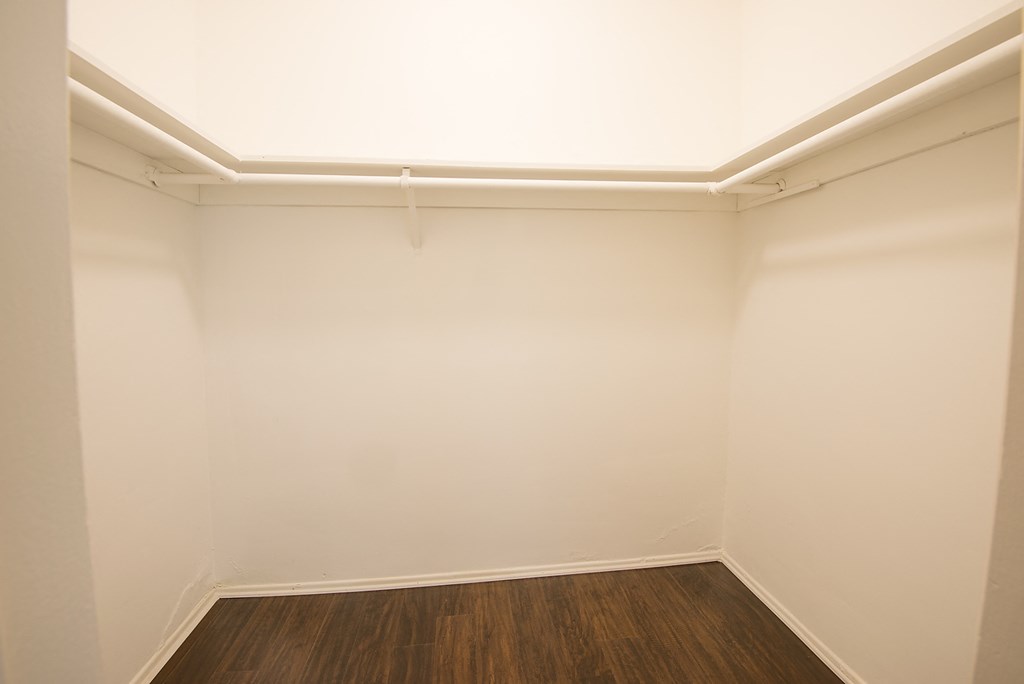 an empty room with white walls and a wooden floor