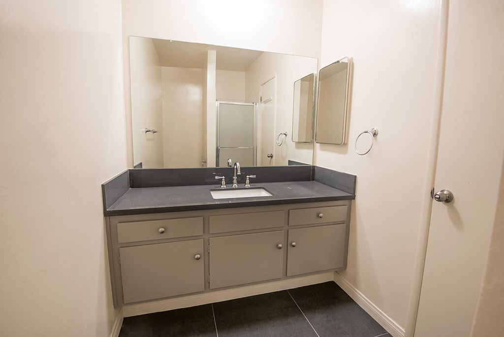 an empty bathroom with a sink and a mirror