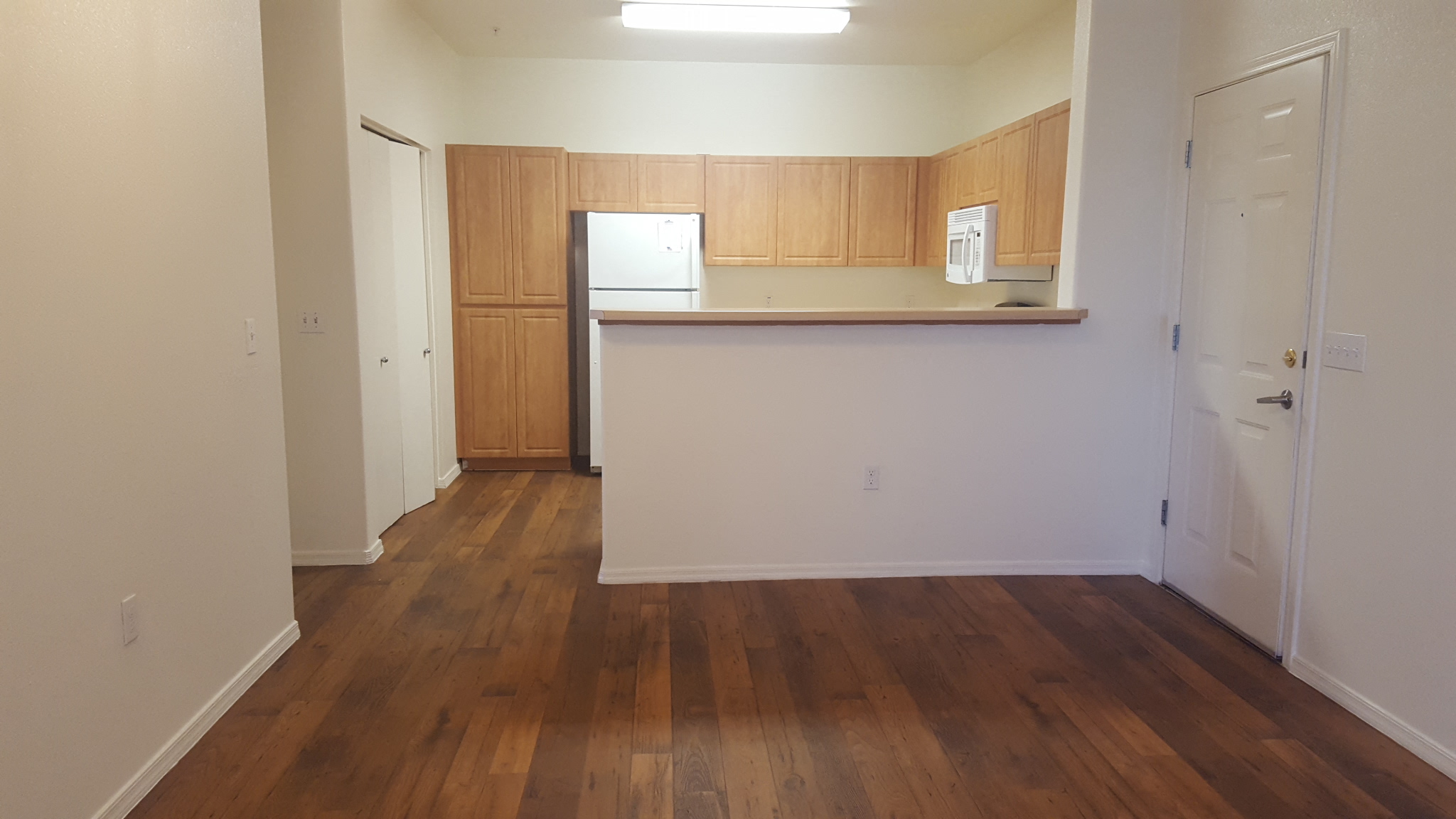 an empty living room and kitchen in an empty apartment