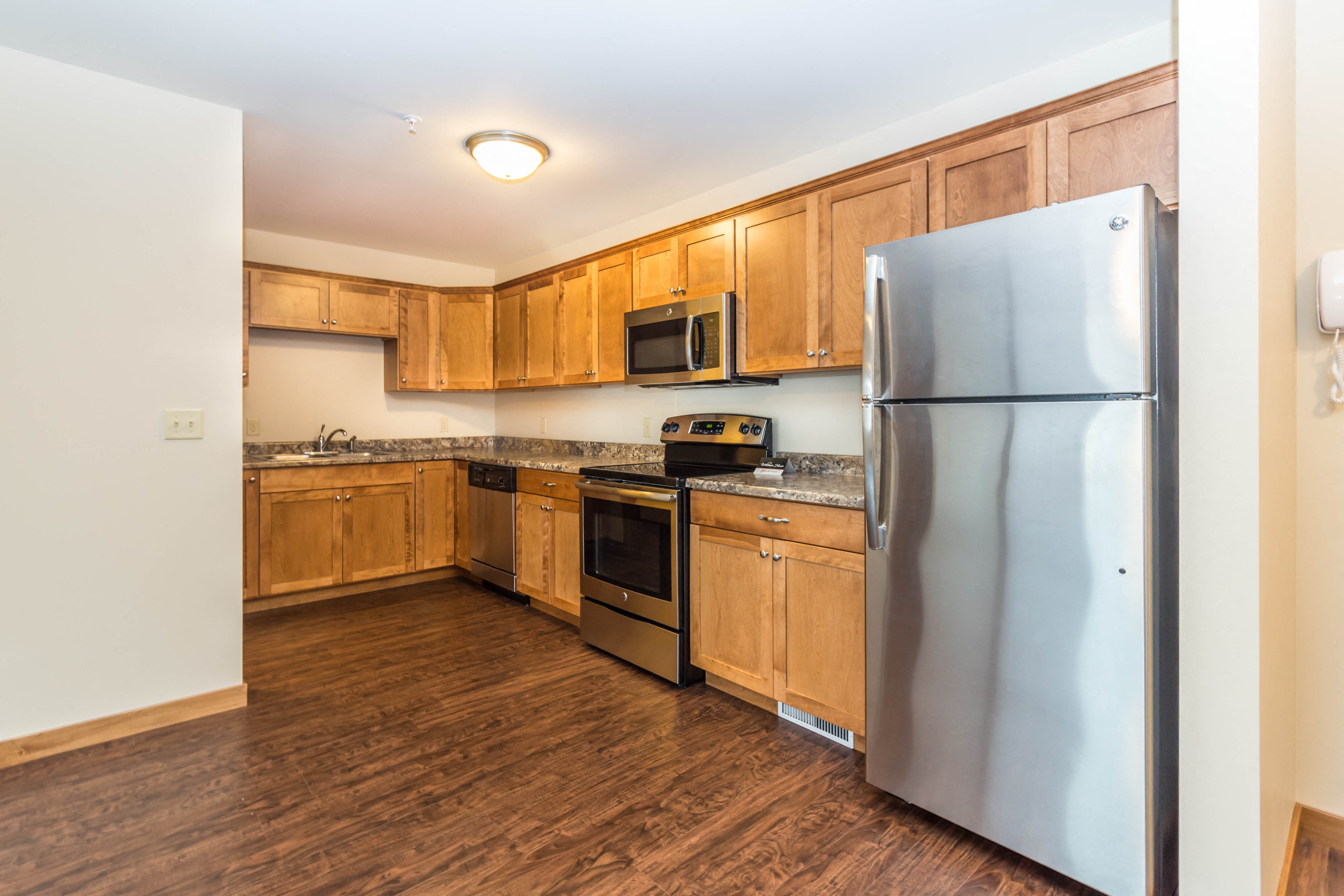 a kitchen with wooden cabinets and stainless steel appliances